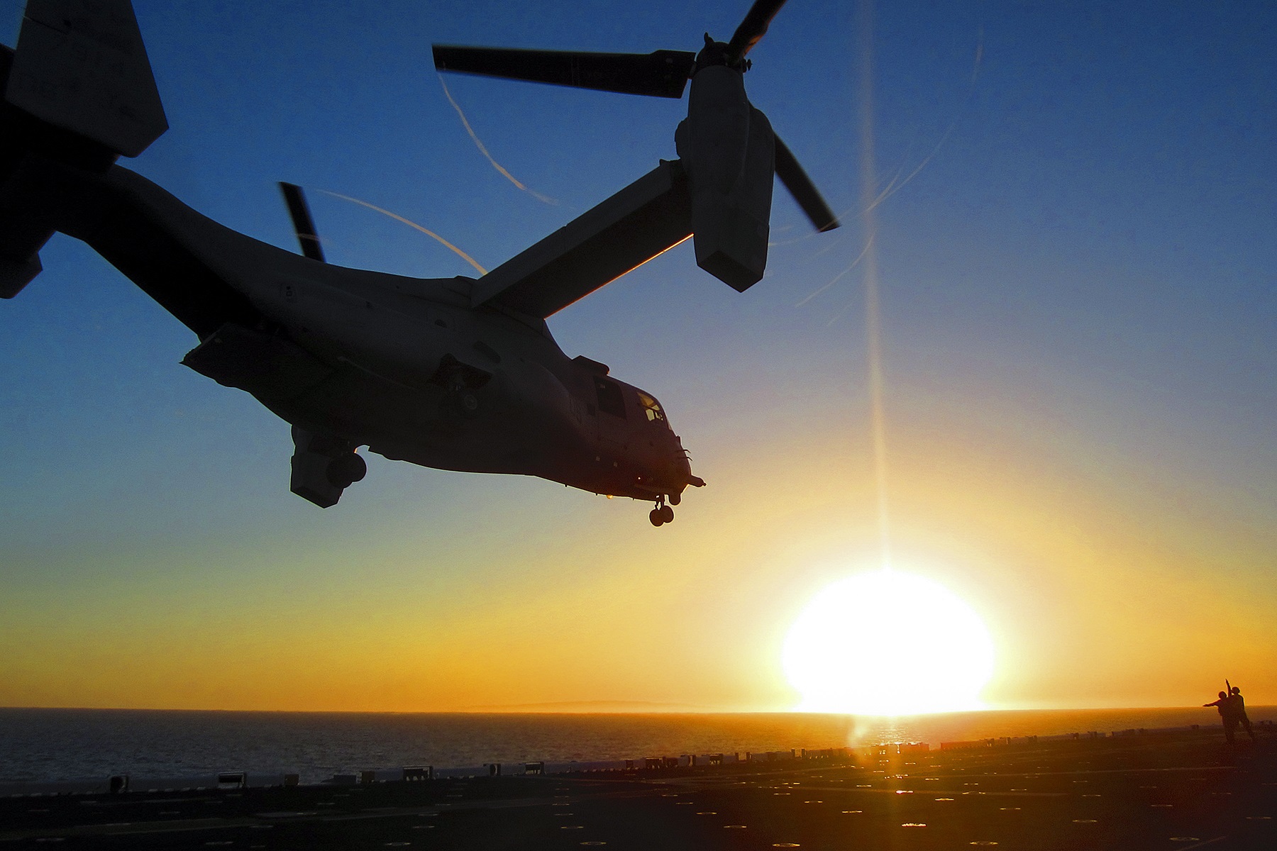 An MV-22 Osprey tilt-rotor aircraft lands on the amphibious assault ship USS America at sunset during deck-landing qualifications in the Pacific Ocean, April 27, 2015. U.S. Marine Corps photo by Chief Warrant Officer 4 Shane Duhe