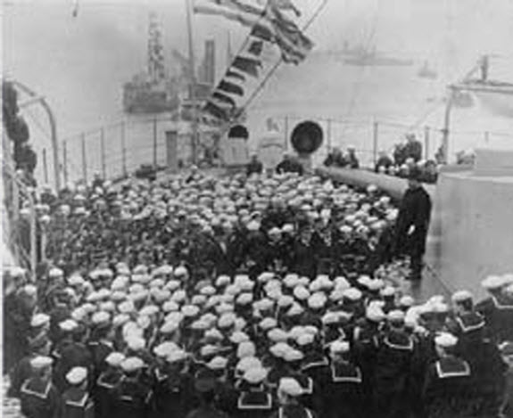 President Theodore Roosevelt adressing officers and men onboard U.S.S Connecticut (BB-18) at Hampton Roads, Virginia, after cruise around the world by the Great White Fleet, 1909. NH 1836.