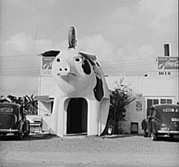 Photo:  restaurant with a huge pig, with an opening between the front legs that functions as its entrance.