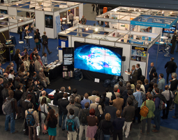 Photo of crowd watching video presentation on large Hyperwall screen