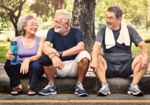 3 elderly people siting on a stoop