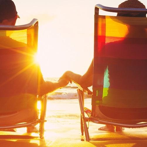 This is an image of a couple holding hands on the beach
