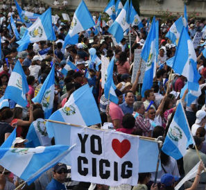 People hold national flags and a sign reading I love CICIG (International Commission Against Impunity in Guatemala) as they take part in a Aug. 22 demonstration in Guatemala City demanding President Otto Perez’s resignation. / Johan Ordonez, AFP