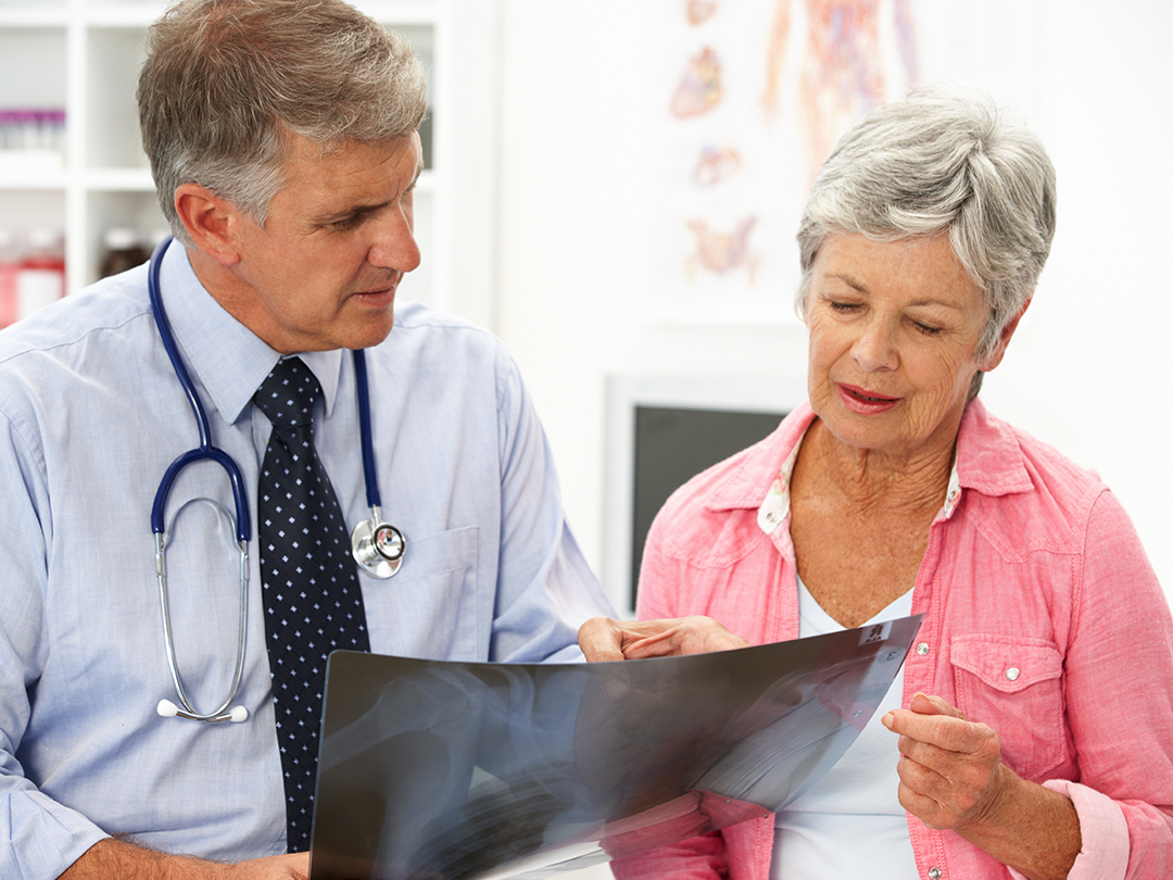 Male Doctor Talking with an Elderly Female Patient About a Digital Image