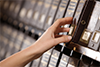 Photo of a hand pulling a book from a shelf