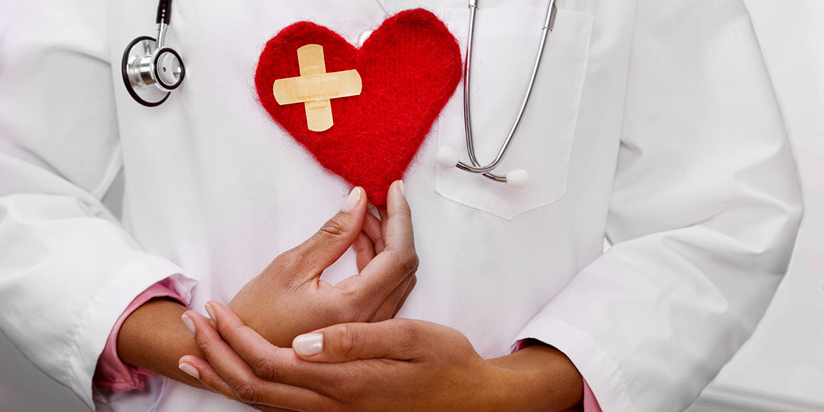 A doctor holding a heart-shaped patch at her  chest.