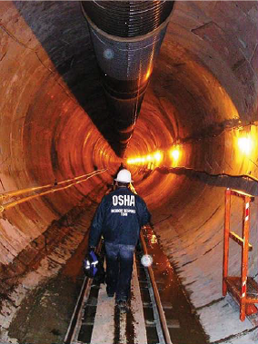 OSHA inspector walking through utility tunnel