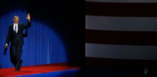 El presidente Obama en un escenario, saludando a la multitud (© AP Images)