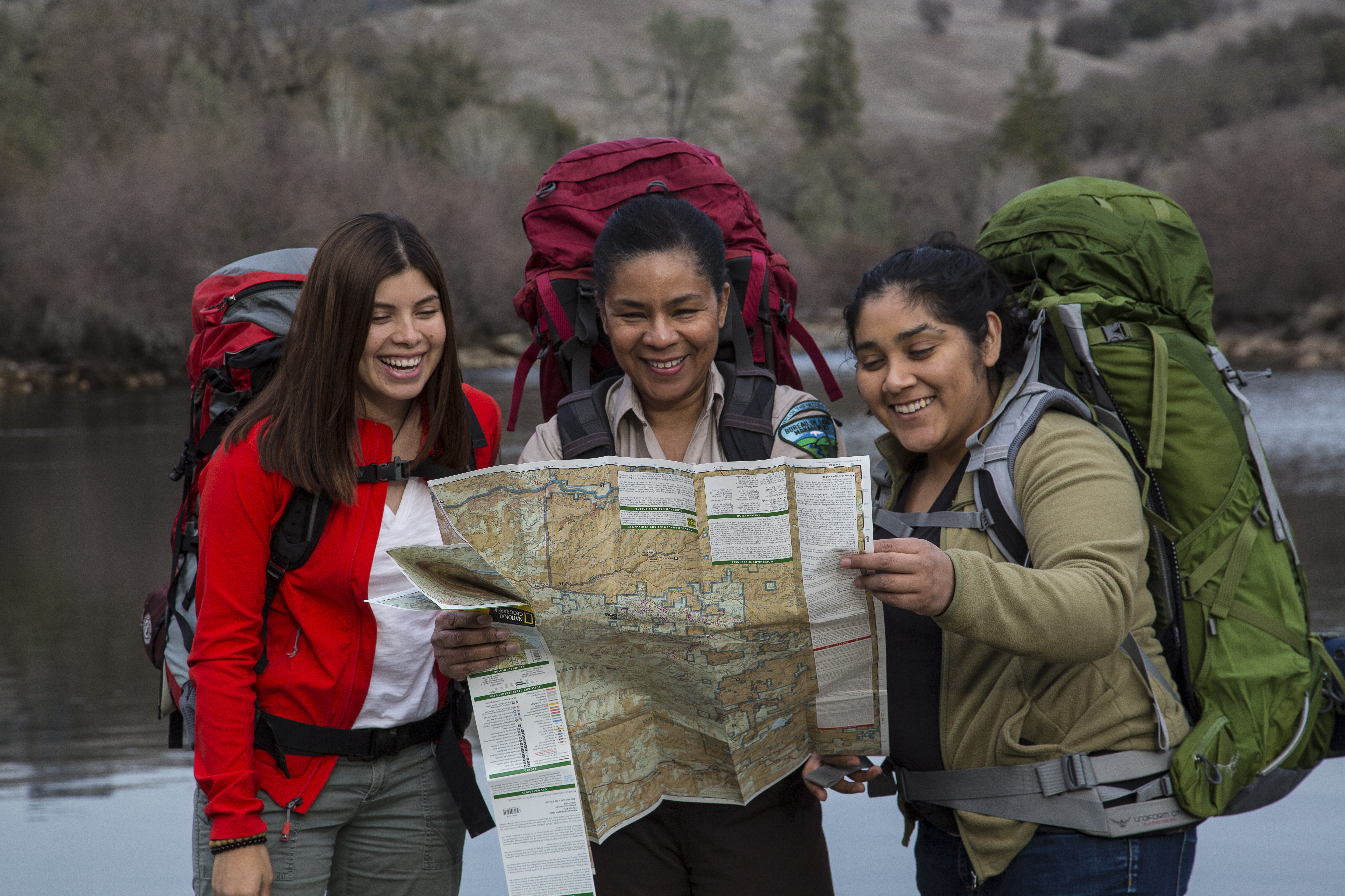 A BLM guide  helps two young hikers read a map.