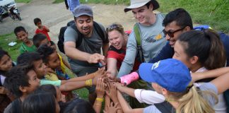 Un groupe d’adultes et d’enfants, les mains jointes au centre du groupe (Photo offerte par Ingénieurs sans frontières USA)