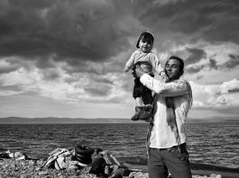 Un hombre sostiene a un niño en una playa rocosa (© Tom Stoddart/Getty Images/Foto cedida por Espacio Annenberg de Fotografía)