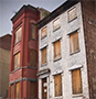 Row houses with boarded windows.