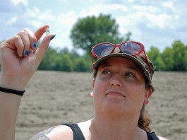 Woman holding up diamond between her thumb and finger (Crater of Diamonds State Park via AP)