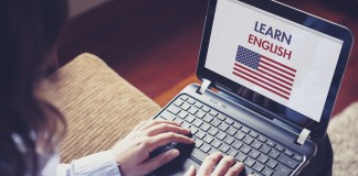 Persona con una computadora portátil que dice “aprende inglés” (© AP Images)