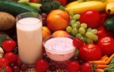 Display of healthy fruits, vegetables and a glass of milk and cup of yogurt