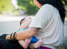 A mom breastfeeding her baby outside