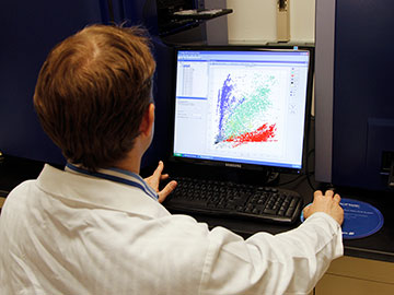 A male scientist analyzing data on a computer.
