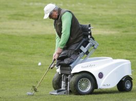 Un homme, les jambes amputées, jouant au golf à l’aide d’un scooter qui lui permet de se positionner (© AP Images)