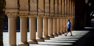 Man walking toward building columns (© AP Images)