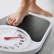 Photograph of the feet of a woman stepping on a scale