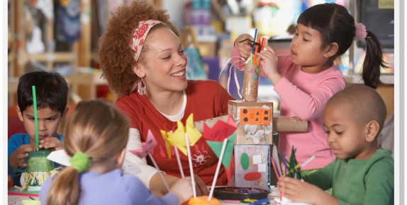 teacher making crafts with four children in classroom