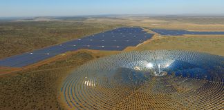 Des panneaux solaires installés dans une plaine, en cercle, autour d’une tour (© SolarReserve)