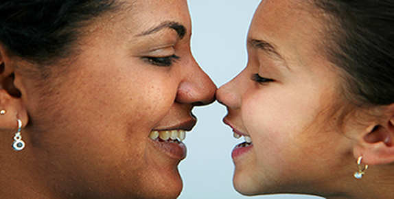 Mother and daughter touching noses and smiling