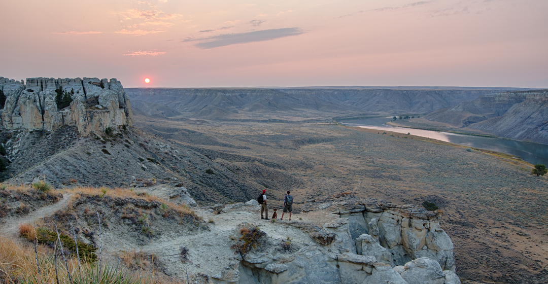 Hikers watch the sun set along the Upper Missouri River.