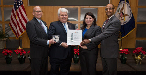 Michael Johnson, NRC Deputy Executive Director for Operations (right), and Vonna Ordaz, Acting Director of the NRC Office of New Reactors (second from right) receive NuScale's application to certify the company's small modular reactor design from NuScale Chief Nuclear Officer Dale Atkinson (second from left) and NuScale Vice President for Regulatory Affairs Tom Bergman (left).