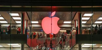 Red apple sign in store window (© AP Images)
