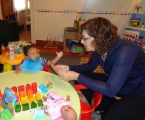 Preschool teacher with young child