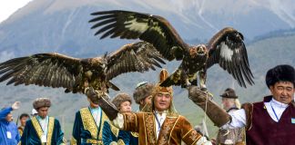 Men walking and holding up eagles (© AP Images)