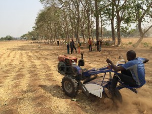 Field engineer, Mathew, stress tests Smart Tractor at test farm in Kaduna as kids from nearby village look. / Jehiel Oliver.