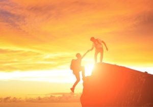 two people hiking with a sunset