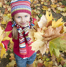 Little girl playing in leaves