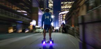 Uma pessoa andando de hoverboard à noite (© AP Images)