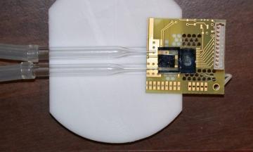 Picture of Prototype microchip device combining NIST's miniature atomic magnetometer with a fluid channel for studies of tiny samples.