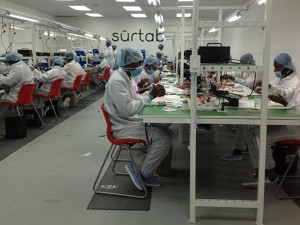 Workers at Haiti’s Surtab factory carefully assembly tablets.