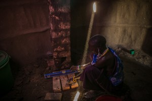 ESILALEI, TANZANIA - FEBRUARY 4, 2014:  Through the creation of solar powered micro-grids, Maasai of the Moduli district in northern Tanzania are receiving power in their mud huts inside their bomas (corralled community). The solar power is providing life-saving water purification, a shared refrigerator for food and medicines, a computer for the community, and lights for the cow and goat corrals to frighten away the hyenas. The International Collaborative for Science, Education and the Environment (ICSEE) also manufactures and distributes a chimney stove for Maasai homes designed collaboratively with Maasai women and installed by teams of women from each participating village to reduce the intake of smoke and carbon dioxide when cooking over traditional fires inside the home.  Footage by Morgana Wingard