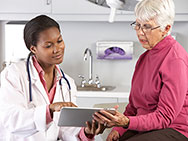 A Female Doctor Talking with a Female Patient Reviewing an iPad