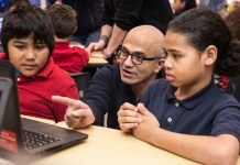 Satya Nadella, le PDG de Microsoft, et deux enfants, regardant l’écran d’un ordinateur (© AP Images)