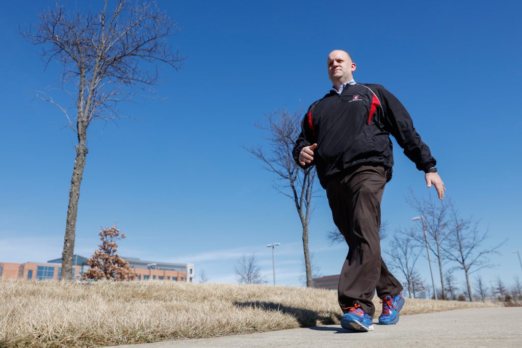 Un hombre camina en el exterior mientras lleva un dispositivo de control de la forma física (© AP Images)