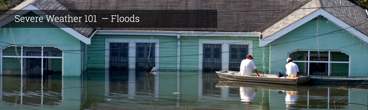 Rescue workers in a boat inspect a flooded house