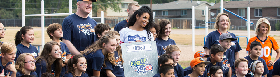 Image of Jordin Sparks and school-aged children posing for picture while holding a sign that says #0to60