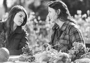 Black and white photo of a teen girl and older woman talking at a picnic