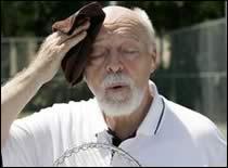 Elderly person with facial hair wiping his brow, presumably in heat distress