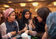 Three women talking at a table. (D.A. Peterson/Dept. of State)