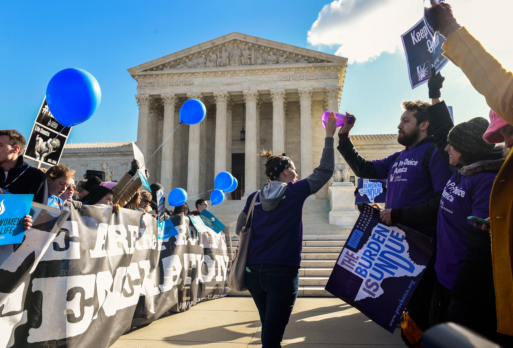 Supreme Court building with groups of people in front of it (© AP Images/Susan Walsh)