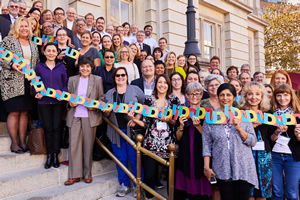 Group of people holding letters of U, D, N