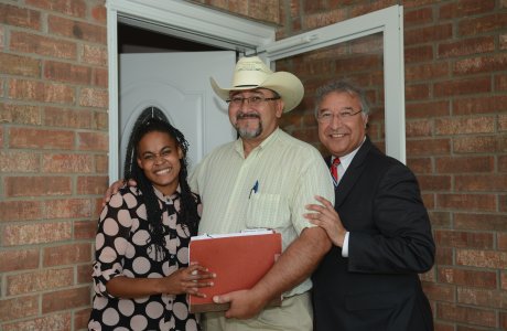 New homeowner poses with RD Administrator and local staff